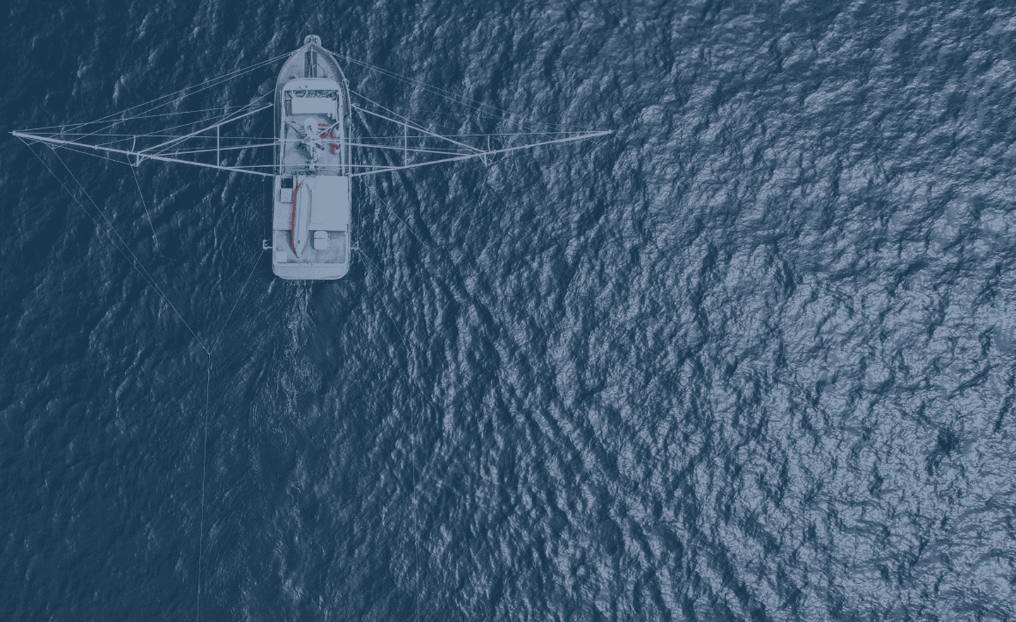 A fishing boat on water from above.