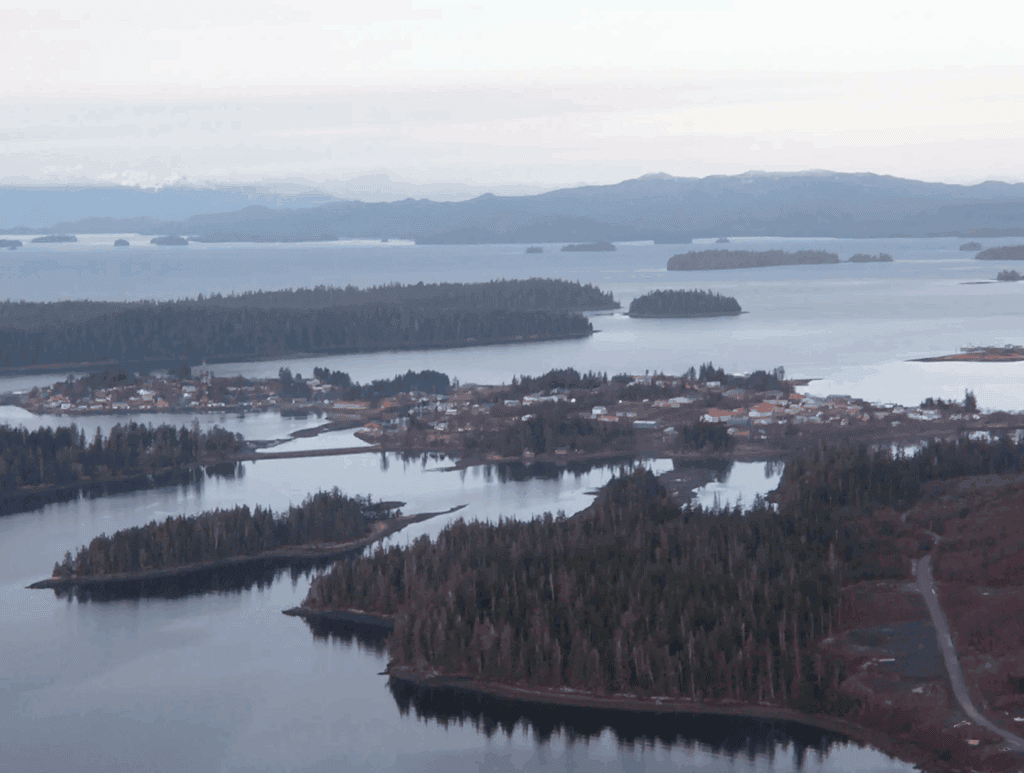 A boat is docked in front of a mountain range.