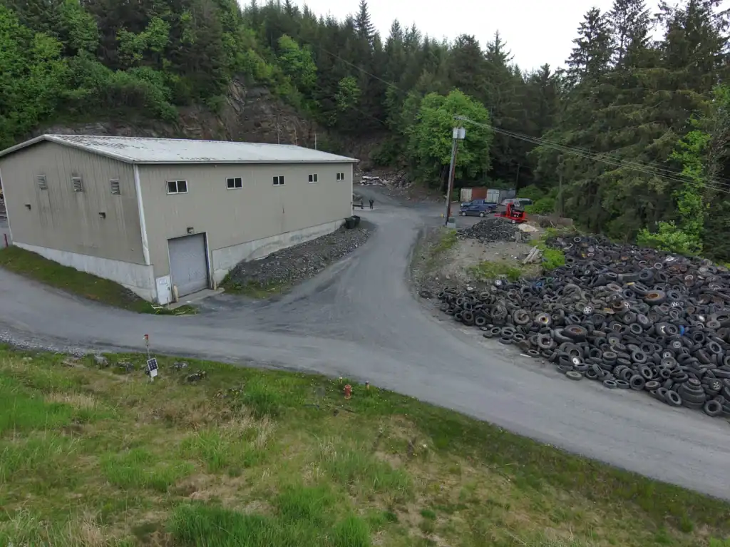 A photo of a building with a large pile of tires to the side.