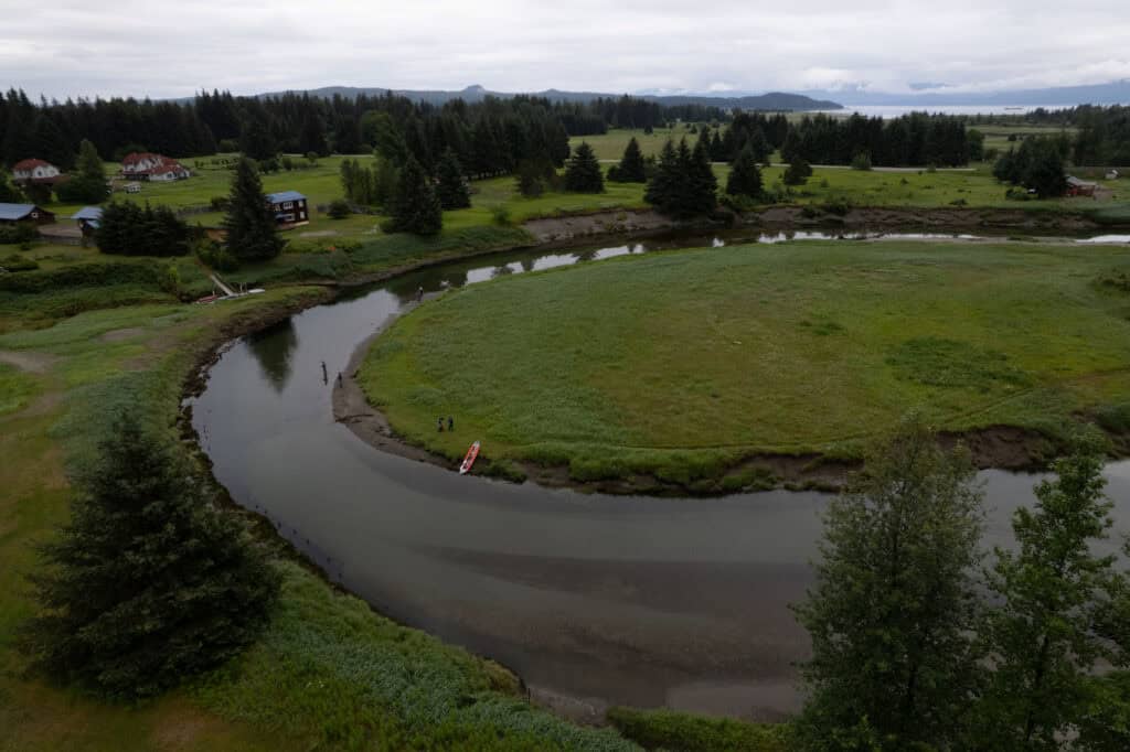 An aerial view of a river with a canoe in it.