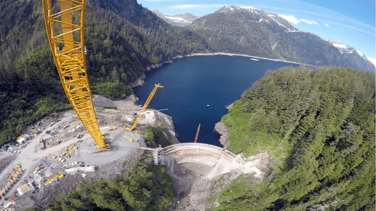 A crane is perched over a dammed lake.