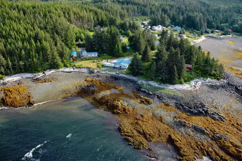 An aerial view of a house on the shore of a body of water.