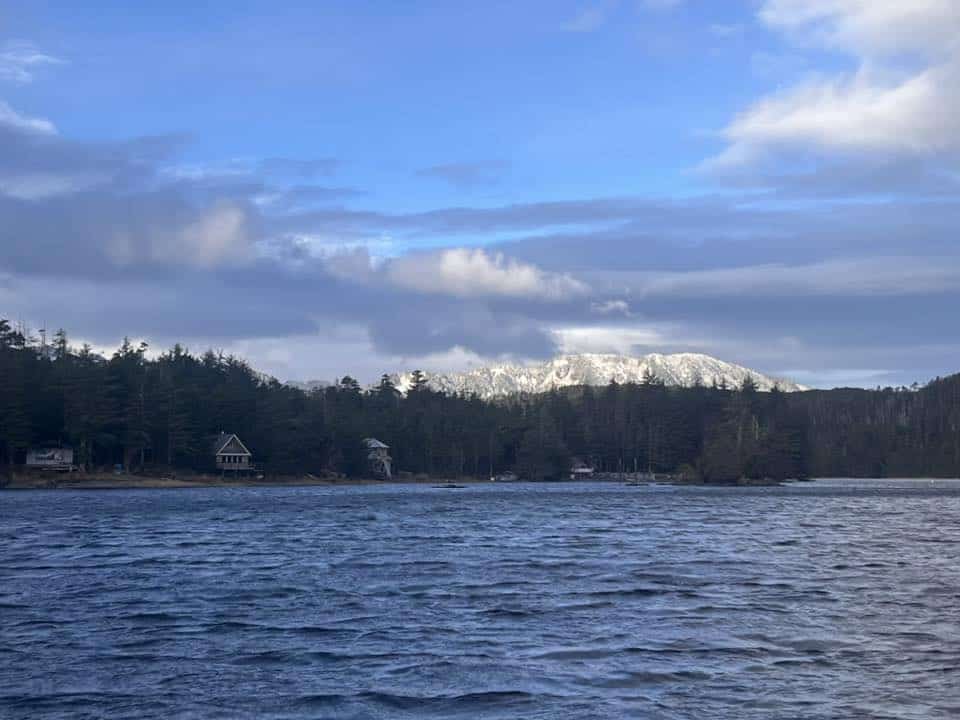 A body of water with snow capped mountains in the background.