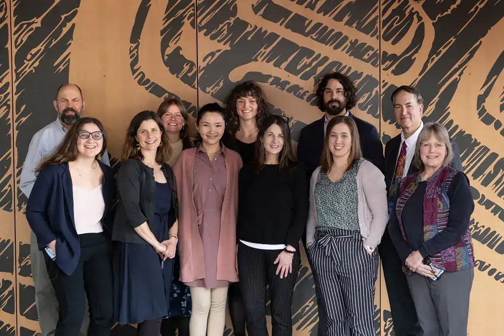 A group of people standing in front of a wall.