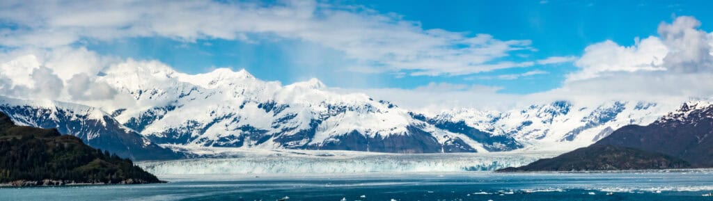A large glacier is surrounded by mountains.